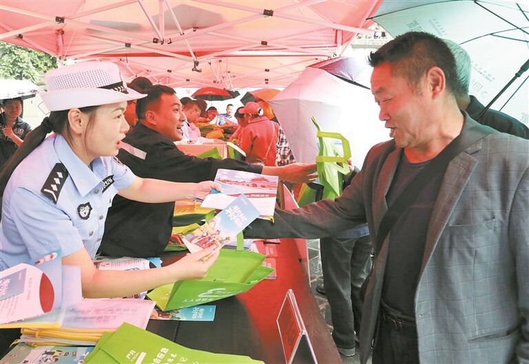 工作人员向过往市民发放宣传资料。赵娜 摄 工作人员向过往市民发放宣传资料。赵娜 摄