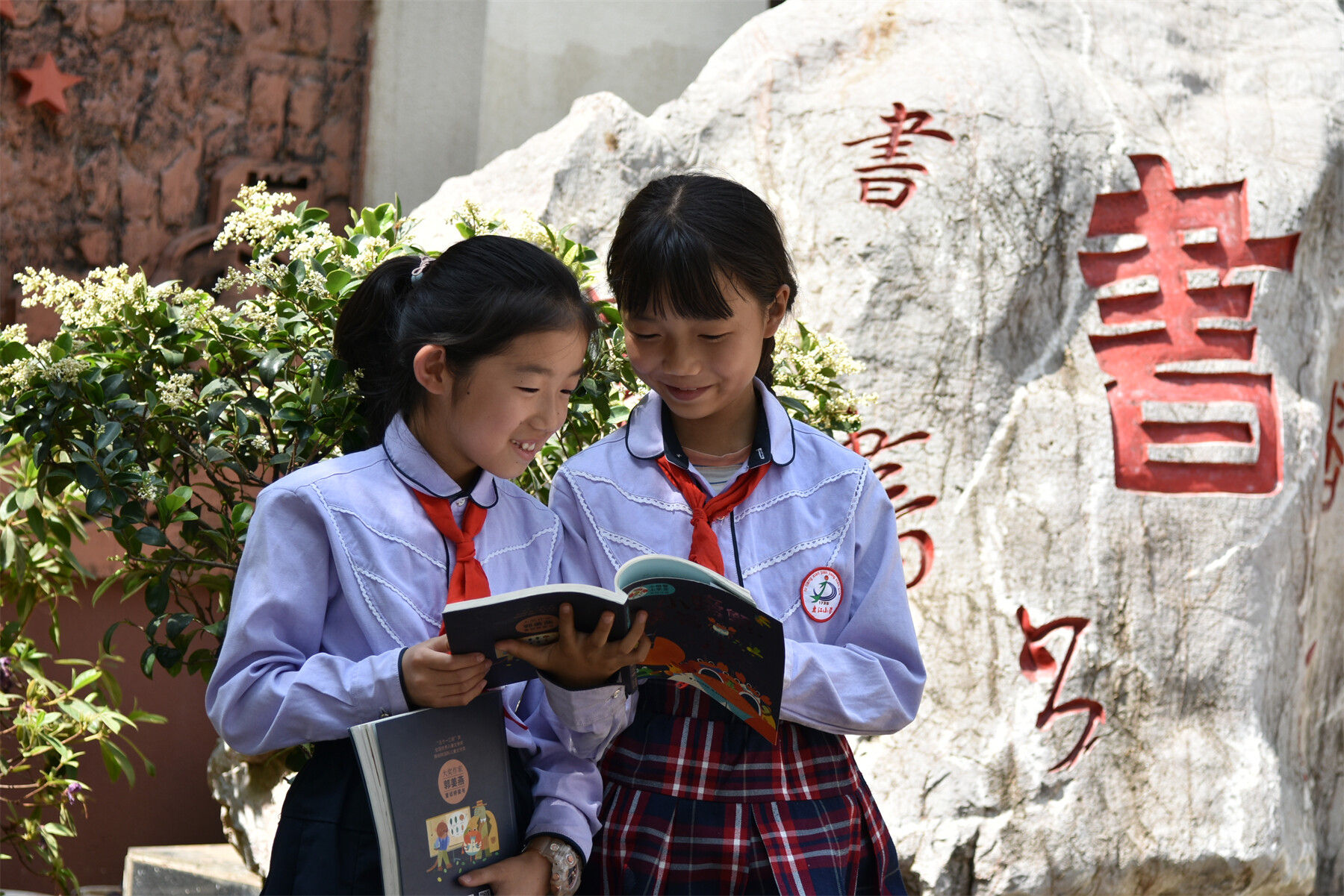 盘江小学学生在校园里开心阅读。