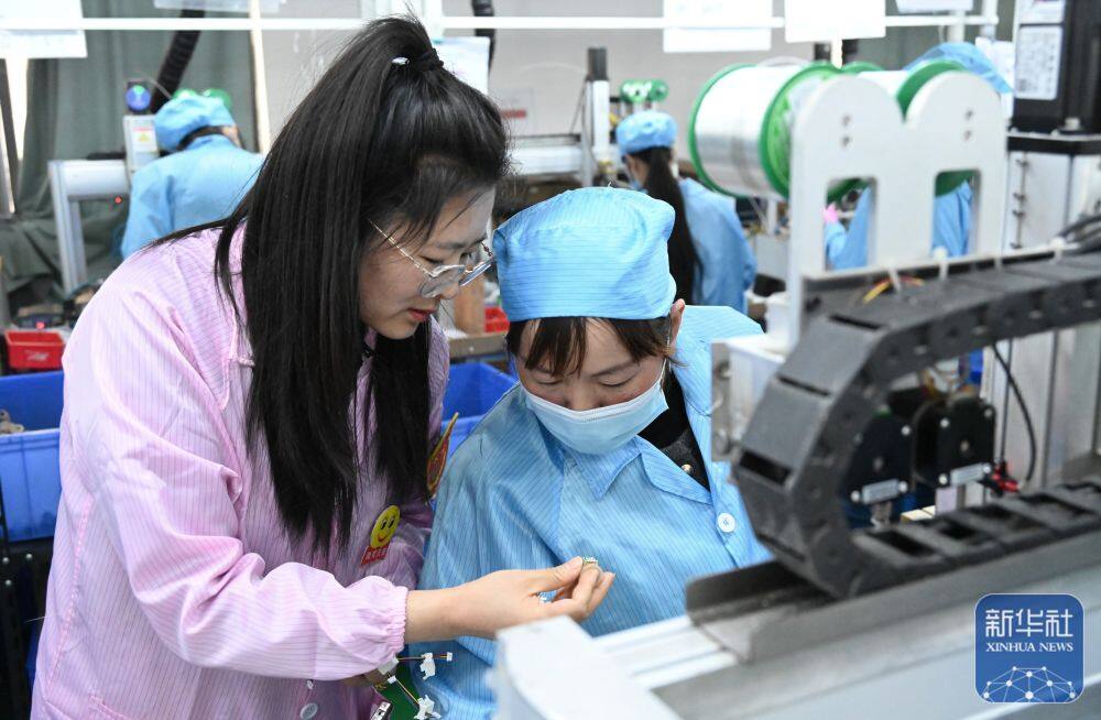 3月25日，陈守利（左）在指导工人提高加工质量。陈守利原来是金钟镇麦地村人，在移居新社区后找到了工作，当上了指导安全员。