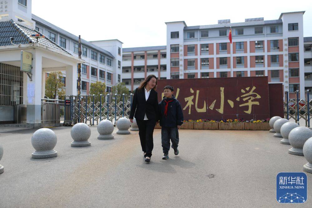 3月25日，易地扶贫安置区居民中午下班后接孩子放学。