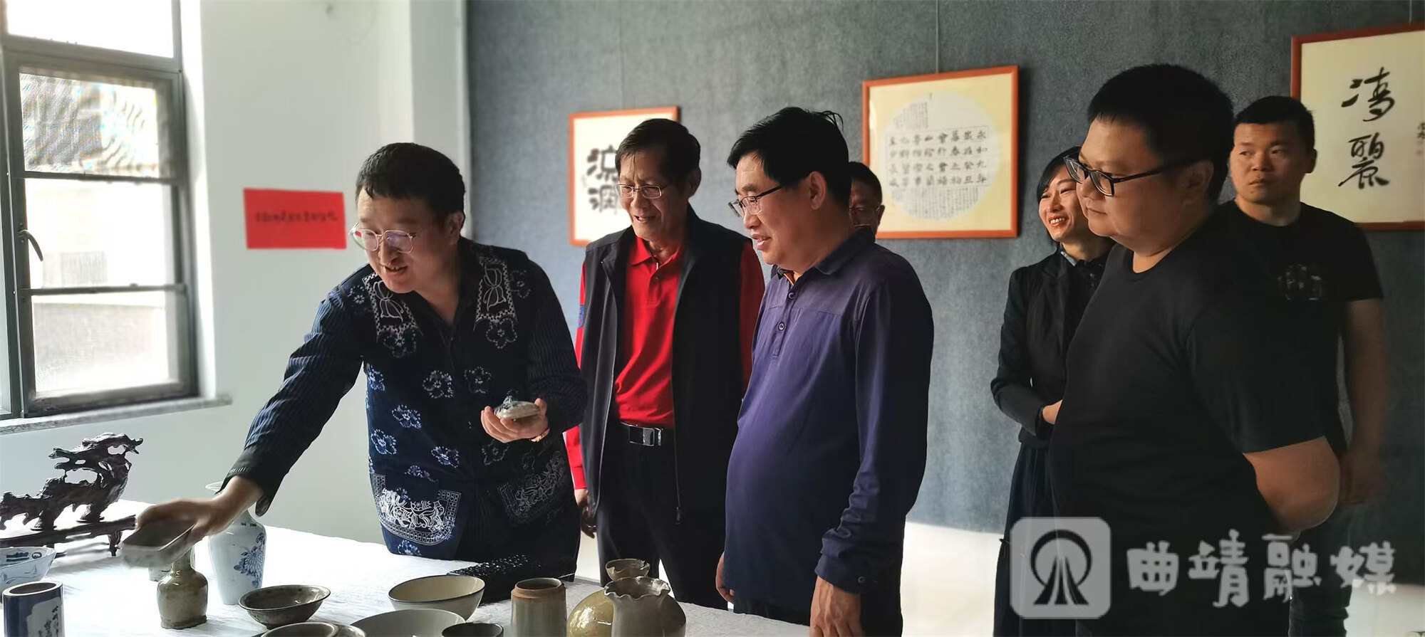 叶炘睿（最左）在艺术展上向参观者介绍曲靖青花