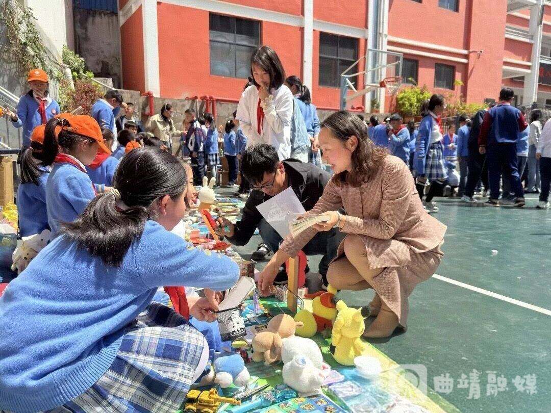 孔令英在校园活动中购买学生售卖的商品。